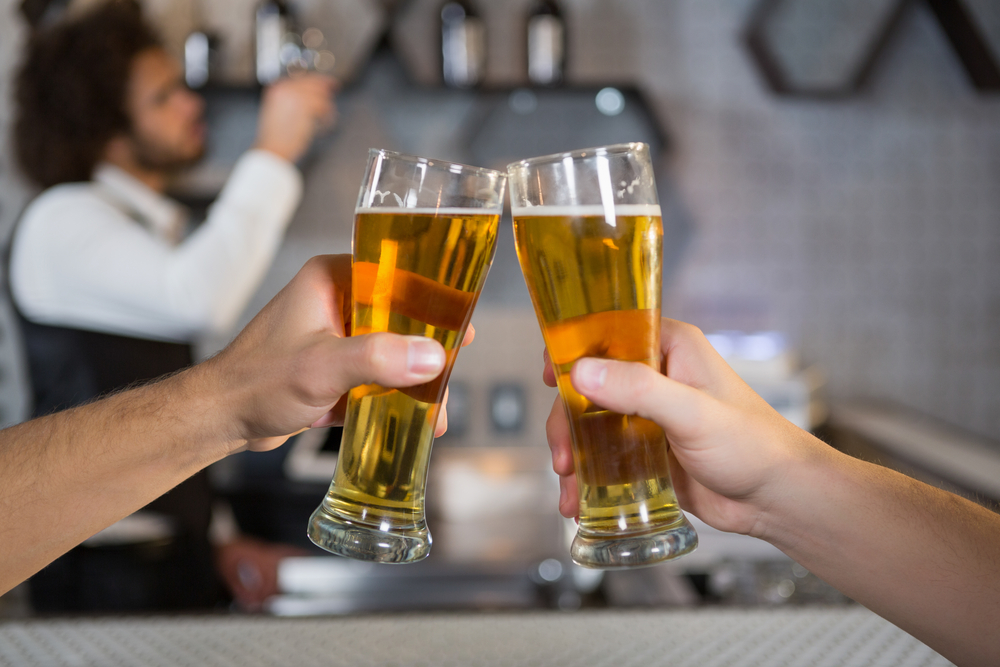 Two men toasting a glass of beer in bar Two men toasting a glass of beer in bar